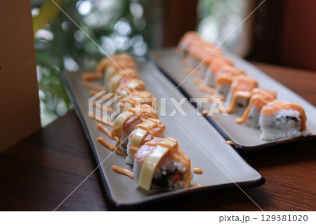 Sushi rolls sauce close-up sushi rolls set rotates. sushi delivery concept. appetizing sushi macro Sushi rolls sauce close-up sushi rolls set rotates. sushi delivery concept. appetizing sushi macro 129381020