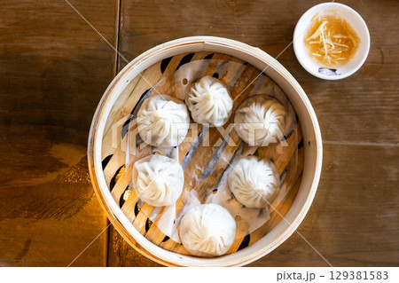Shanghai popular xiaolongbao or little dragon dumpling steamed and served in bamboo basket. 129381583