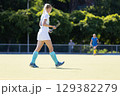 Field hockey player walks on a sunny day during a game at a sports facility 129382279