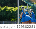 Field hockey players in blue uniforms focus on defending the goal 129382281