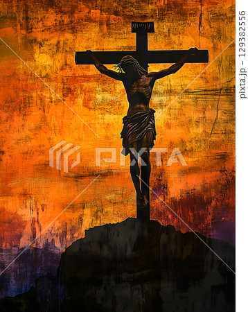Crucifix of Jesus silhouetted against a vibrant mountain sunset sky 129382556