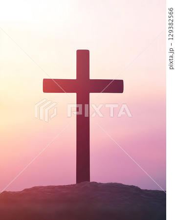 Crucifix symbol of Jesus against a vibrant sunset on a mountain landscape 129382566