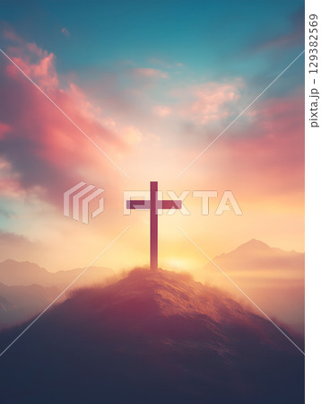 Crucifix symbol of Jesus against a stunning sunset backdrop on a mountain peak Crucifix symbol of Jesus against a stunning sunset backdrop on a mountain peak 129382569
