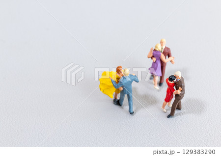 Miniature Couples Dancing on Light Background 129383290