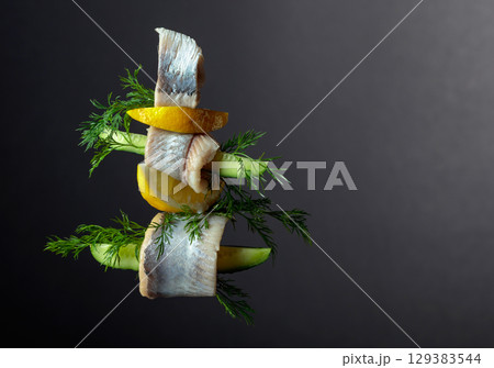 Herring fillet in oil with lemon, cucumber, and dill. 129383544
