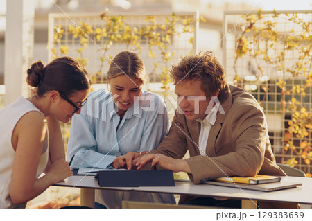 Engaging in a Collaborative Business Meeting Outdoors focusing on Teamwork and Dynamics Engaging in a Collaborative Business Meeting Outdoors focusing on Teamwork and Dynamics 129383639