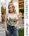 Beautiful slim blonde poses in boho wedding dresses and an embroidered corset on a summer terrace 129384673