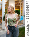 Beautiful slim blonde poses in boho wedding dresses and an embroidered corset on a summer terrace 129384674