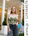 Beautiful slim blonde poses in boho wedding dresses and an embroidered corset on a summer terrace 129384676