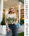 Beautiful slim blonde poses in boho wedding dresses and an embroidered corset on a summer terrace 129384677