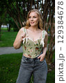 Beautiful slim blonde poses in boho wedding dresses and an embroidered corset on a summer terrace 129384678