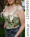 Beautiful slim blonde poses in boho wedding dresses and an embroidered corset on a summer terrace 129384680