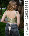 Beautiful slim blonde poses in boho wedding dresses and an embroidered corset on a summer terrace 129384681