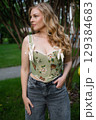 Beautiful slim blonde poses in boho wedding dresses and an embroidered corset on a summer terrace 129384683