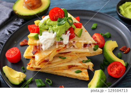 quesadilla with cheese, bacon, avocado on a plate 129384713