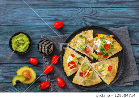 quesadilla with cheese, bacon, avocado on a plate 129384714