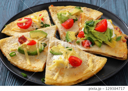 quesadilla with cheese, bacon, avocado on a plate 129384717