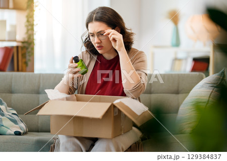 Woman is unpacking cardboard 129384837