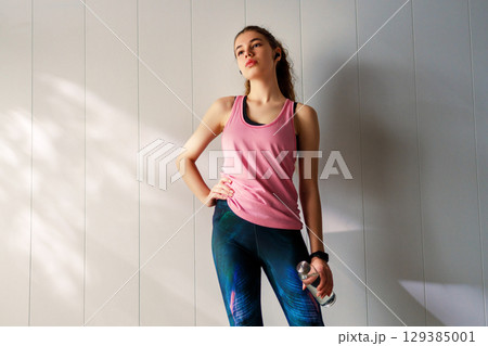 Woman in fashionable sportswear is doing exercise. Woman in fashionable sportswear is doing exercise. 129385001