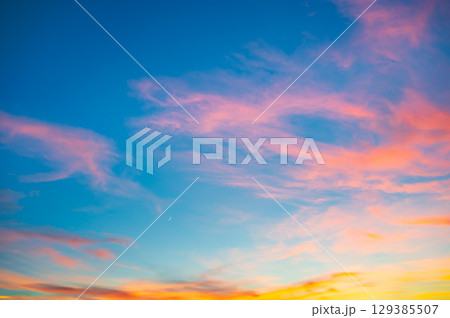 鮮やかな夕焼け空と三日月 129385507