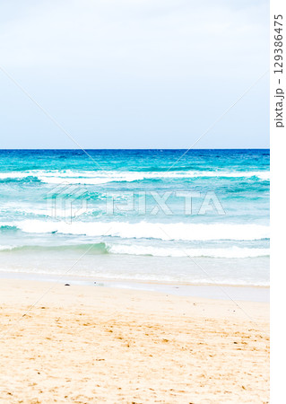 エメラルドグリーンの波が押し寄せる遠浅の砂浜　フエルテベンテュラ島の海岸 129386475