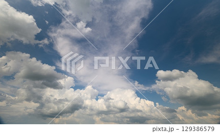 A Beautiful, Dreamy Cloudy Sky with a Stunning Blue Background Illuminates the Landscape A Beautiful, Dreamy Cloudy Sky with a Stunning Blue Background Illuminates the Landscape 129386579