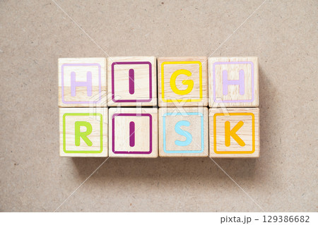 Alphabet letter block in word high risk on wood background 129386682