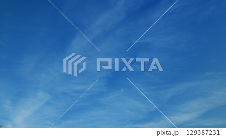 A Vast Clear Blue Sky with Delicate Thin Clouds Gracefully Floating Above, Evoking Peace A Vast Clear Blue Sky with Delicate Thin Clouds Gracefully Floating Above, Evoking Peace 129387231