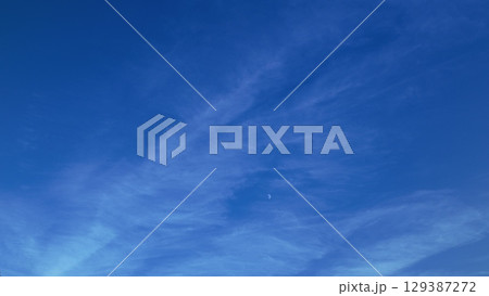 A Beautiful Blue Sky Adorned with Wispy Clouds and a Subtle Hint of the Moon Above A Beautiful Blue Sky Adorned with Wispy Clouds and a Subtle Hint of the Moon Above 129387272