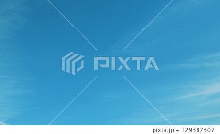 A Clear Blue Sky with Wispy White Clouds Appearing Peaceful and Reflecting Natural Beauty A Clear Blue Sky with Wispy White Clouds Appearing Peaceful and Reflecting Natural Beauty 129387307