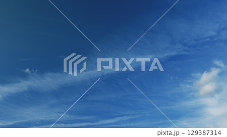 A stunningly clear blue sky adorned with delicate wispy clouds, creating a beautiful scene A stunningly clear blue sky adorned with delicate wispy clouds, creating a beautiful scene 129387314