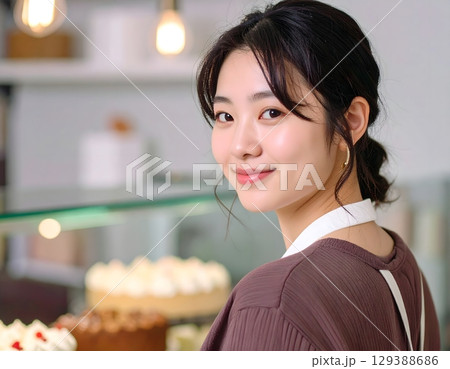 素敵なケーキと一緒に微笑む店員のポートレート 129388686