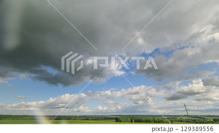 A Dynamic and EverChanging Cloudscape Over Serene and Lush Green Fields and Horizons 129389556
