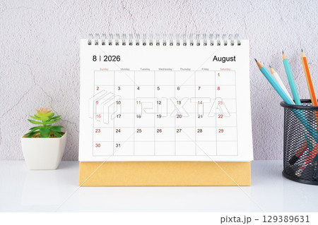 August 2026 Desk Calendar with wooden pencil on white table. 129389631