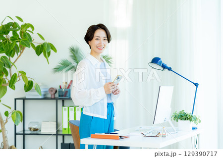 オフィスでスマホを操作するビジネスウーマン オフィスでスマホを操作するビジネスウーマン 129390717
