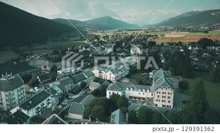 Drone aerial view of Villard-de-Lans in the Vercors region, showing residential areas, surrounding fields, and alpine mountains in summer Drone aerial view of Villard-de-Lans in the Vercors region, showing residential areas, surrounding fields, and alpine mountains in summer 129391362