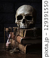 Skull on antique books with hourglass. 129391550