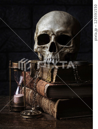 Skull on antique books with hourglass. 129391550