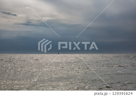 Calm sea horizon under cloudy blue sky Calm sea horizon under cloudy blue sky 129391624