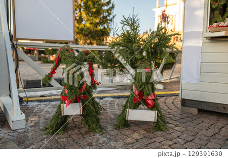 Handmade Christmas reindeer decorations made of spruce branches with red bows Handmade Christmas reindeer decorations made of spruce branches with red bows 129391630