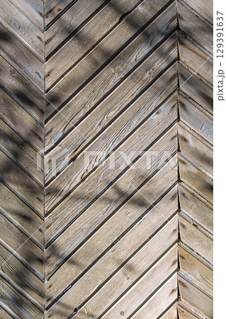 A beautifully crafted Textured Wooden Chevron Pattern showcased in the warm embrace of Natural Light 129391637