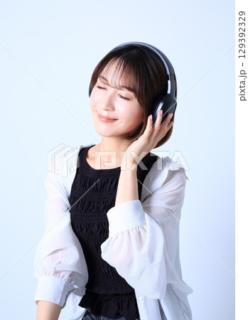 ヘッドホンで音楽を聴く女性イメージ 129392329