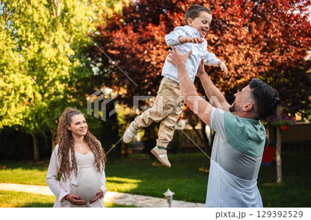 Joyful family moment under blooming trees in springtime 129392529