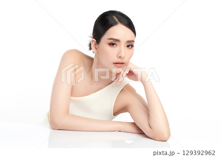 A beautiful young Asian woman with clean, fresh skin against a white background. Skincare, facial treatment, cosmetology, beauty, and spa. An elegant portrait of an Asian woman. 129392962