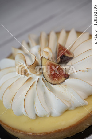 Sunny and Bright Orange Lemon Citrus Meringue Pie on a black plate on white background 129392995