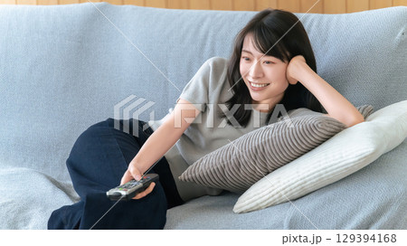 ソファに寝転んでテレビを見る女性 ソファに寝転んでテレビを見る女性 129394168