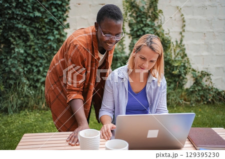 Two businesswomen working on a laptop outdoors 129395230