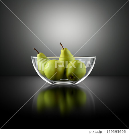 Green pears in a glass bowl. A bowl of pears isolated on a black background.	 129395696