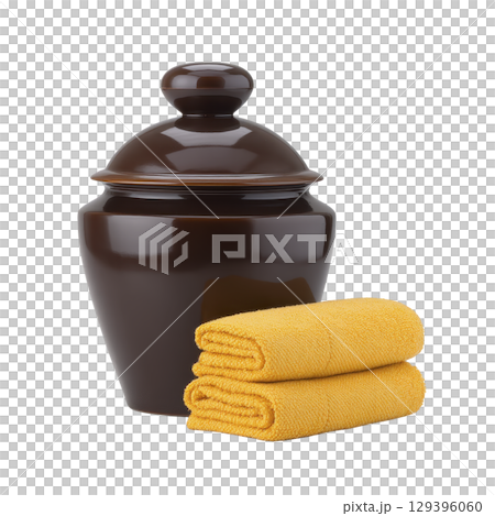 Glossy brown ceramic jar with lid is paired with two neatly folded yellow towels, creating harmonious and cozy arrangement 129396060