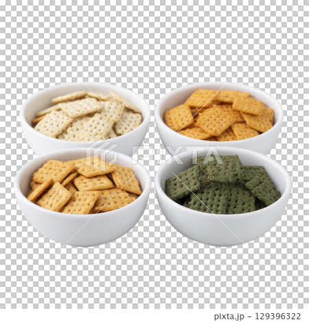 Four white bowls filled with assorted crackers different colors, including white, orange, brown, and green, are arranged square pattern. crackers are neatly stacked, showcasing variety of flavors 129396322
